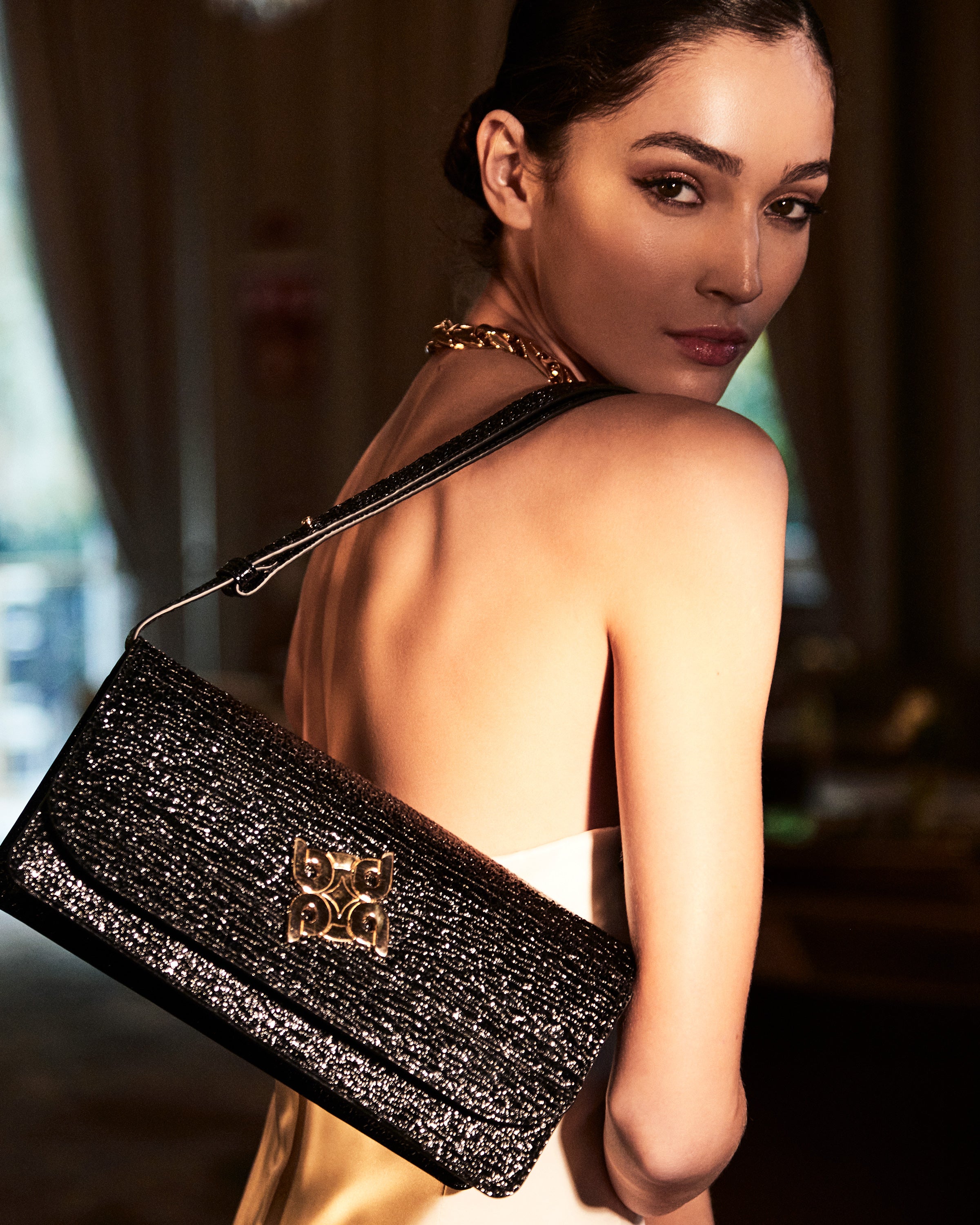 Modelo posando con bolso baguette de piel caprino, combinando estilo sofisticado y exclusividad